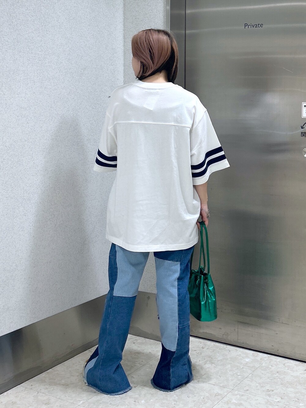 ブルー系のデニムパンツ、グリーン系のショルダーバッグ、ベージュ系のサンダルを着用したレディースの夏コーディネートの3枚目の写真