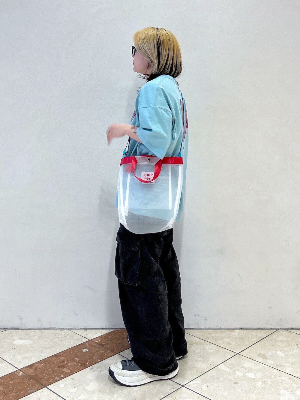 グリーン系のTシャツ/カットソー、ブラック系のカーゴパンツ、ホワイト系のショルダーバッグを着用したレディースの春コーディネートの3枚目の写真