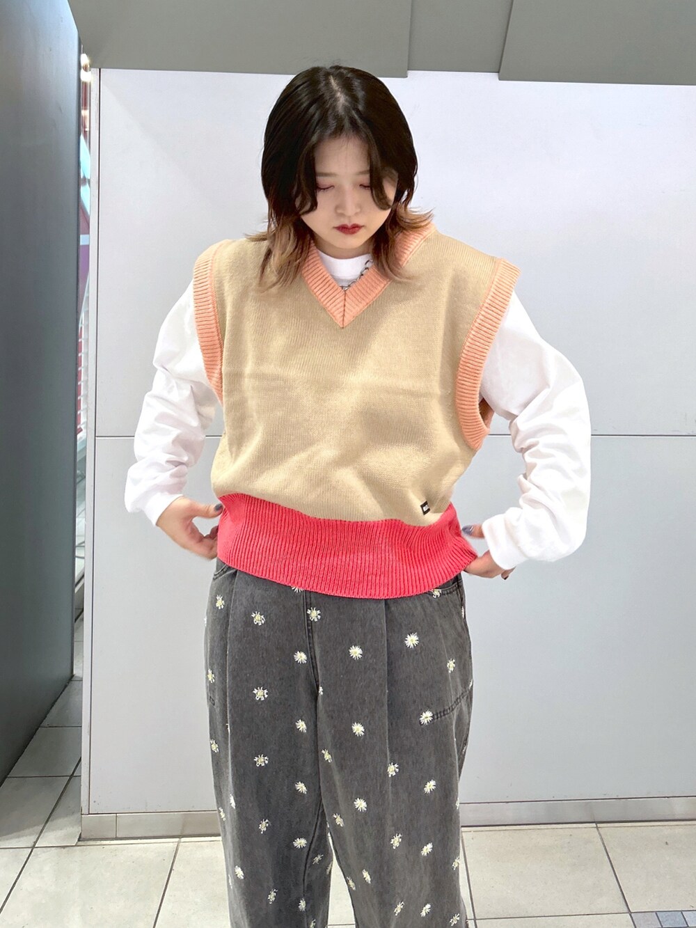 ベージュ系のベスト、ホワイト系のTシャツ/カットソー、ホワイト系のショルダーバッグを着用したレディースの秋コーディネートの3枚目の写真