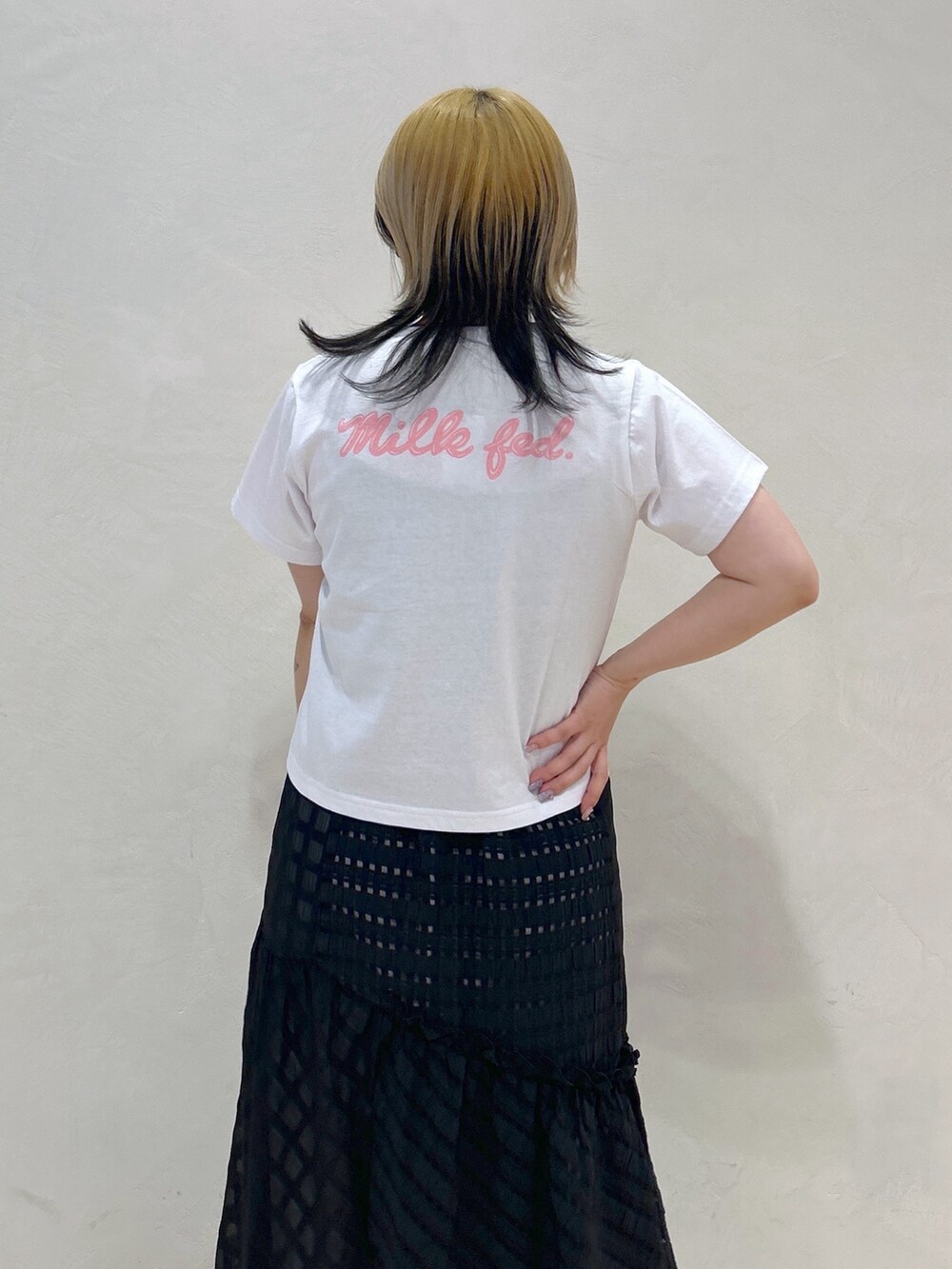 ピンク系のTシャツ/カットソー、ブラック系のスカート、ブラック系のハンドバッグを着用したレディースの春コーディネートの3枚目の写真