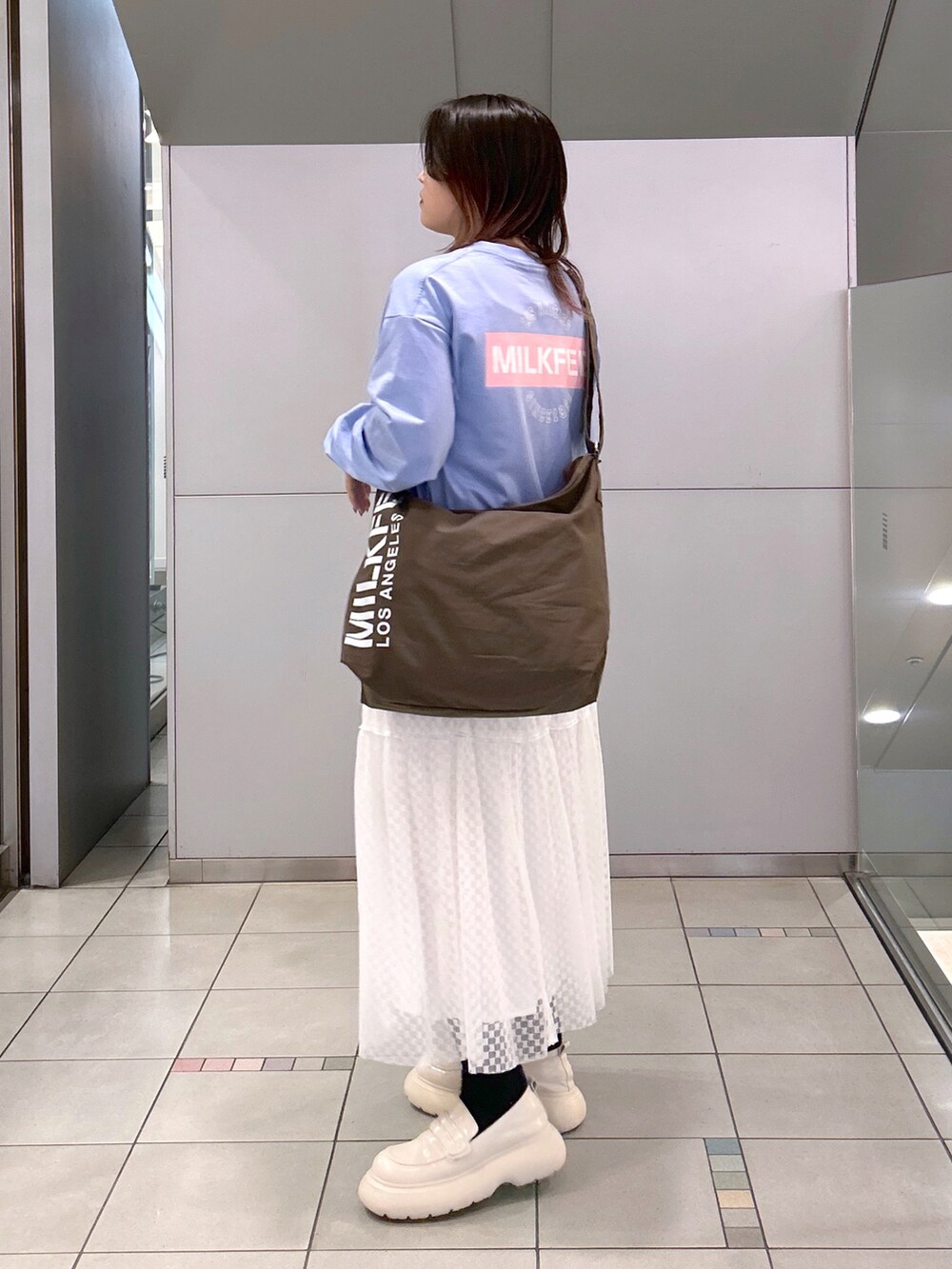 ブルー系のTシャツ/カットソー、ブラウン系のショルダーバッグ、ホワイト系のスカートを着用したレディースの夏コーディネートの3枚目の写真