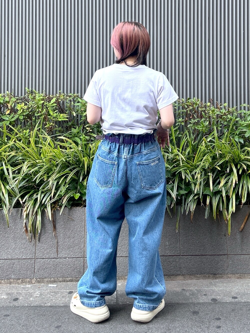 ブルー系のデニムパンツ、ホワイト系のTシャツ/カットソー、ベージュ系のサンダルを着用したレディースの夏コーディネートの4枚目の写真