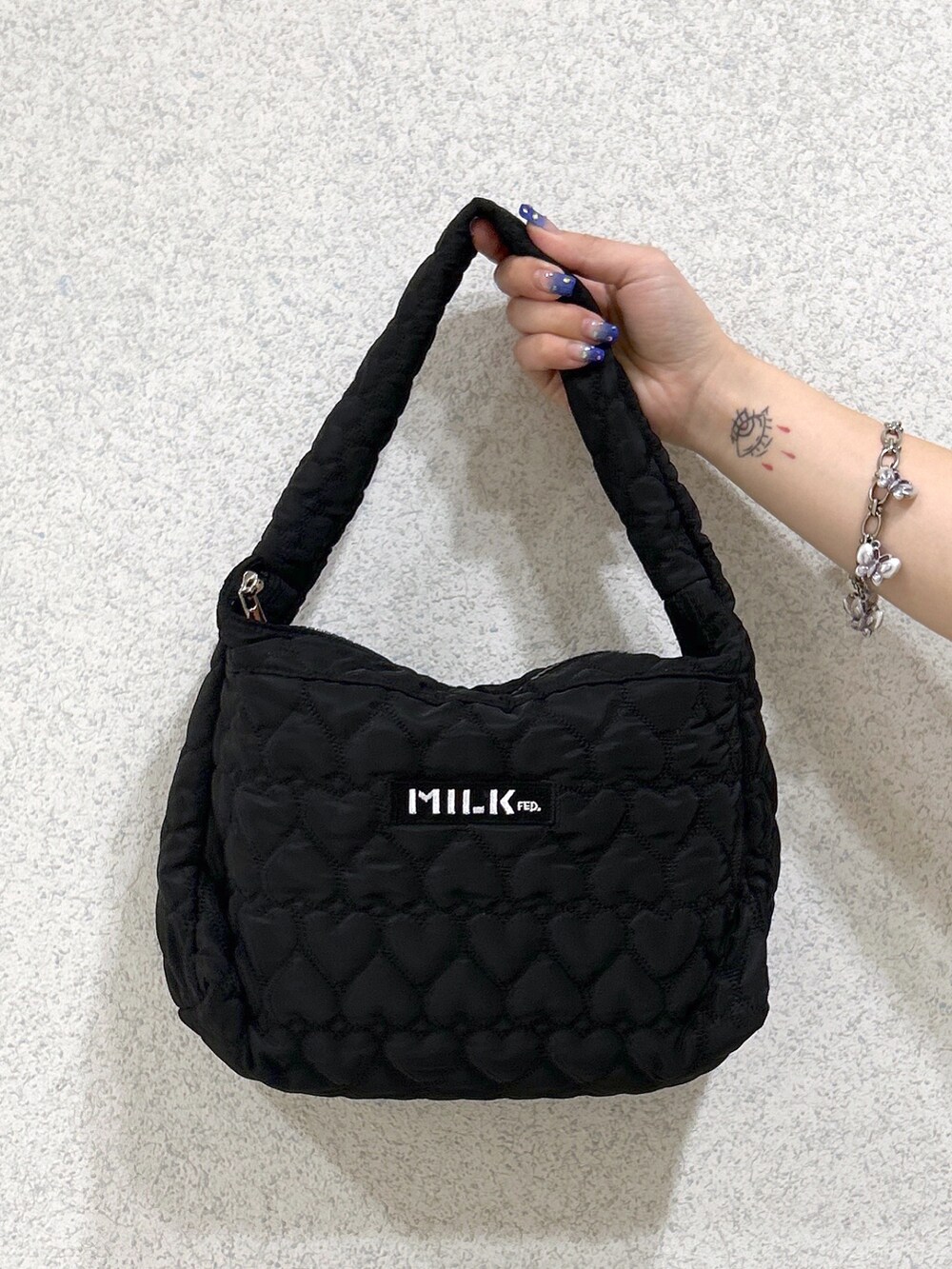 ブラック系のタンクトップ、ブラック系のTシャツ/カットソー、ブラック系のハンドバッグを着用したレディースの夏コーディネートの5枚目の写真