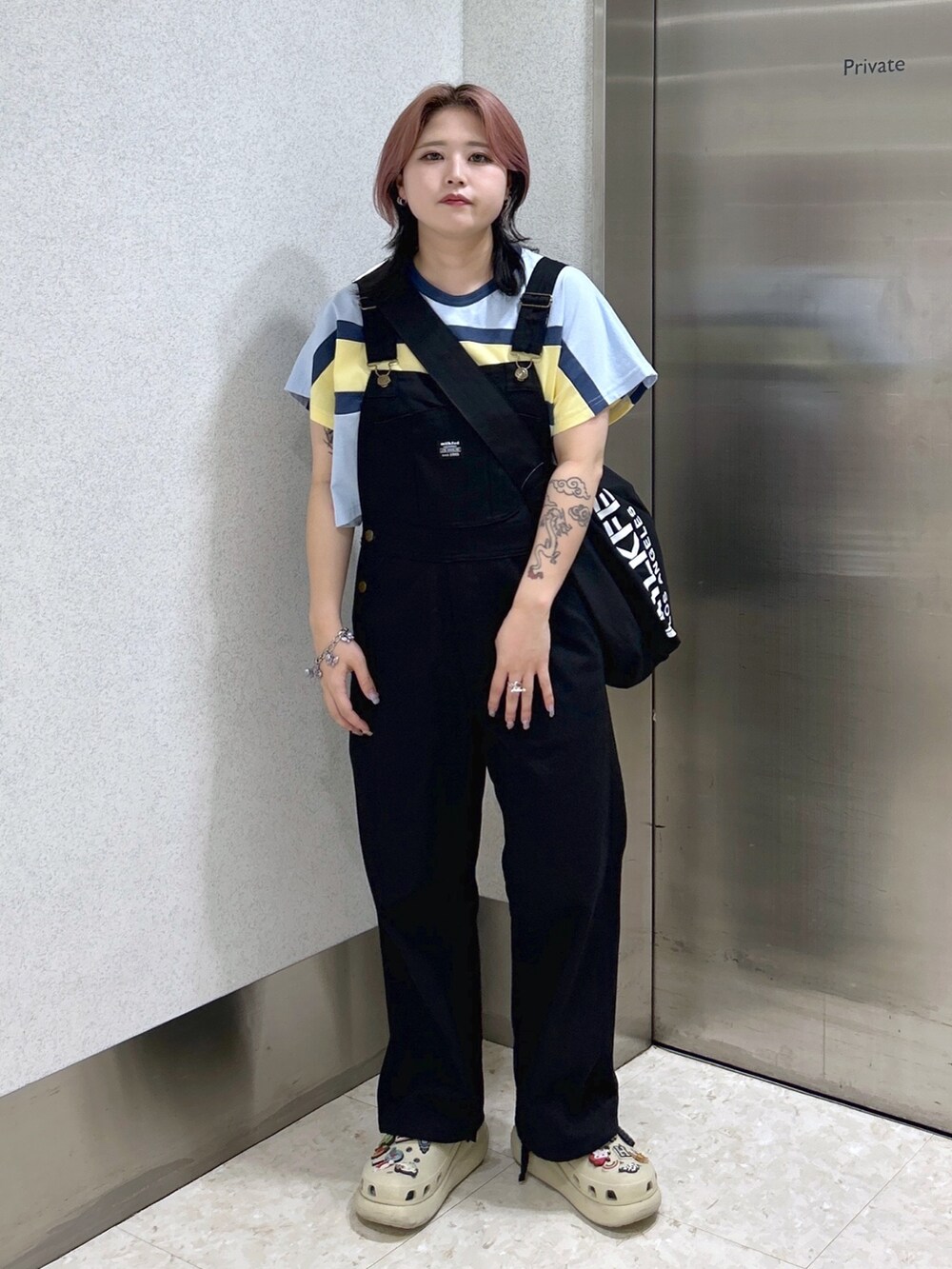 ブラック系のサロペット/オーバーオール、ブラック系のショルダーバッグ、ベージュ系のサンダルを着用したレディースの夏コーディネートの2枚目の写真