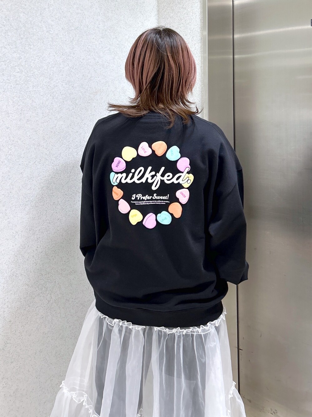 ブラック系のスウェット、ピンク系のショルダーバッグ、ブラック系のブーツを着用したレディースの春コーディネートの5枚目の写真