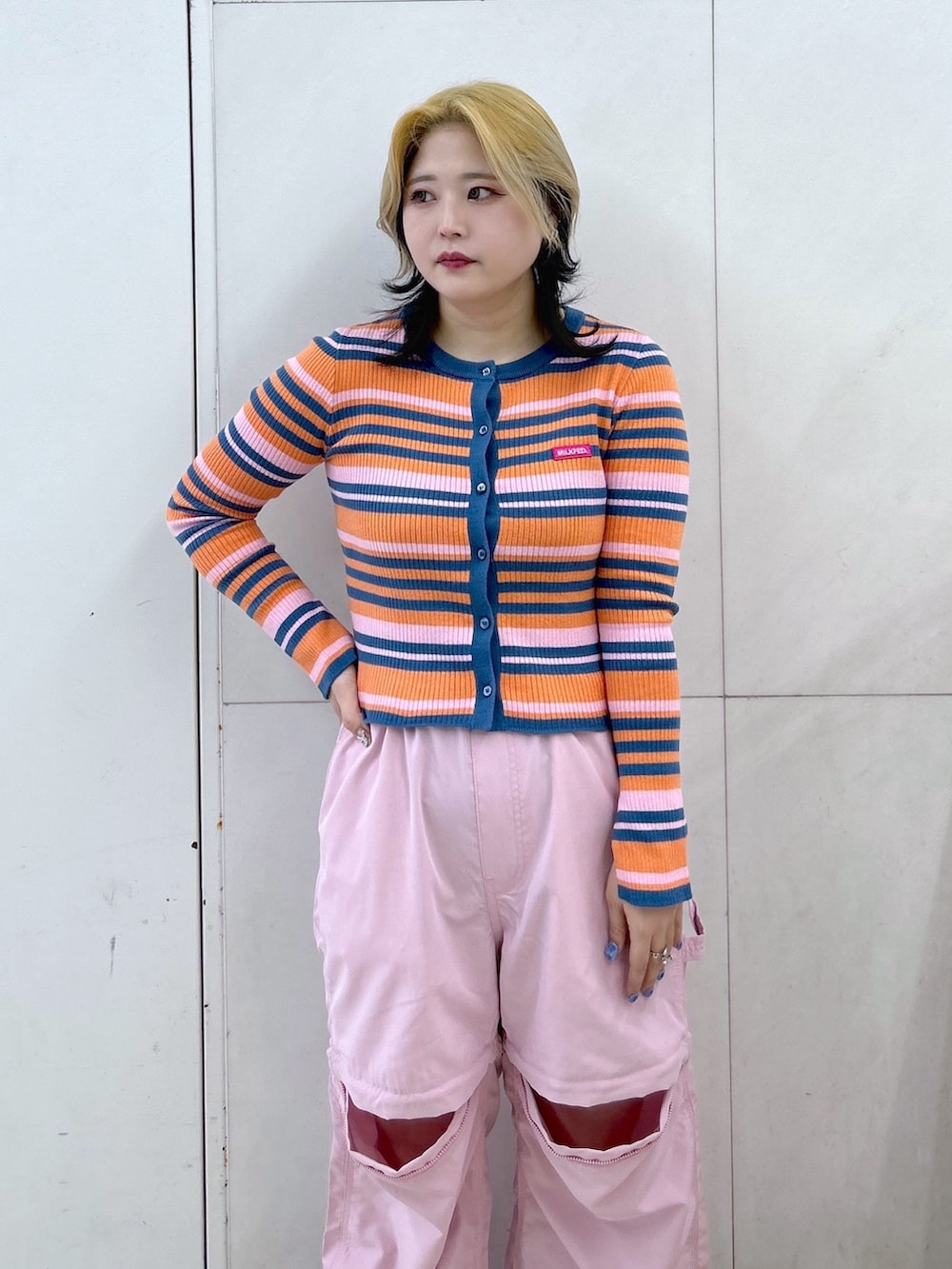 オレンジ系のカーディガン/ボレロ、ピンク系のその他パンツ、ブラック系のハンドバッグを着用したレディースの春コーディネートの6枚目の写真