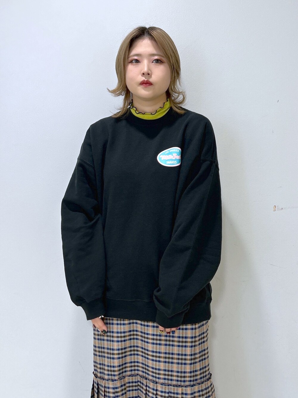 グリーン系のその他トップス、グレー系のスカート、ブラック系のショルダーバッグを着用したレディースの冬コーディネートの4枚目の写真