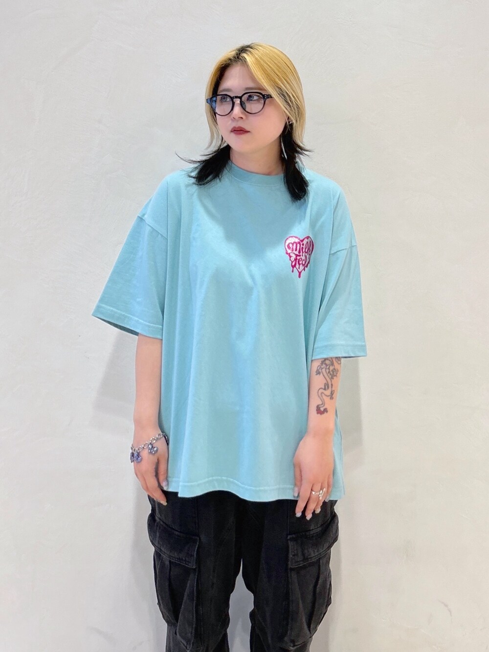 グリーン系のTシャツ/カットソー、ブラック系のカーゴパンツ、ホワイト系のショルダーバッグを着用したレディースの春コーディネートの5枚目の写真