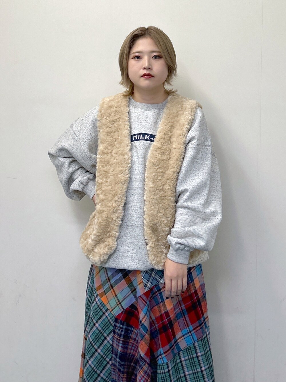 ホワイト系のベスト、その他のスウェット、グリーン系のスカートを着用したレディースの秋コーディネートの3枚目の写真