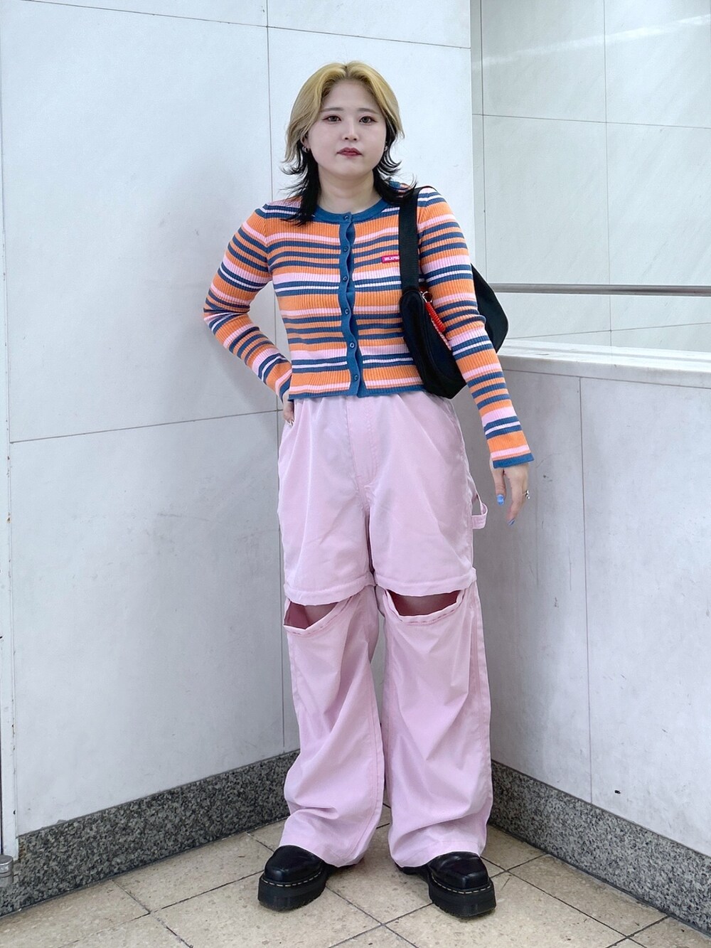オレンジ系のカーディガン/ボレロ、ピンク系のその他パンツ、ブラック系のハンドバッグを着用したレディースの春コーディネートの2枚目の写真