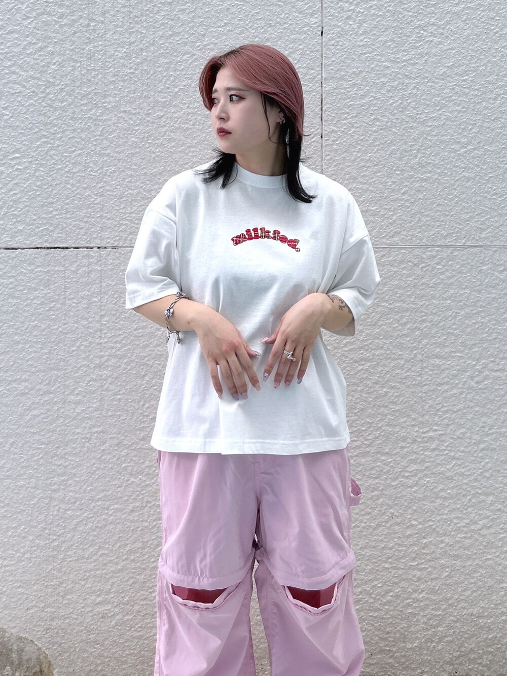 ピンク系のその他パンツ、グリーン系のメッセンジャーバッグ、ホワイト系のTシャツ/カットソーを着用したレディースの春コーディネートの4枚目の写真