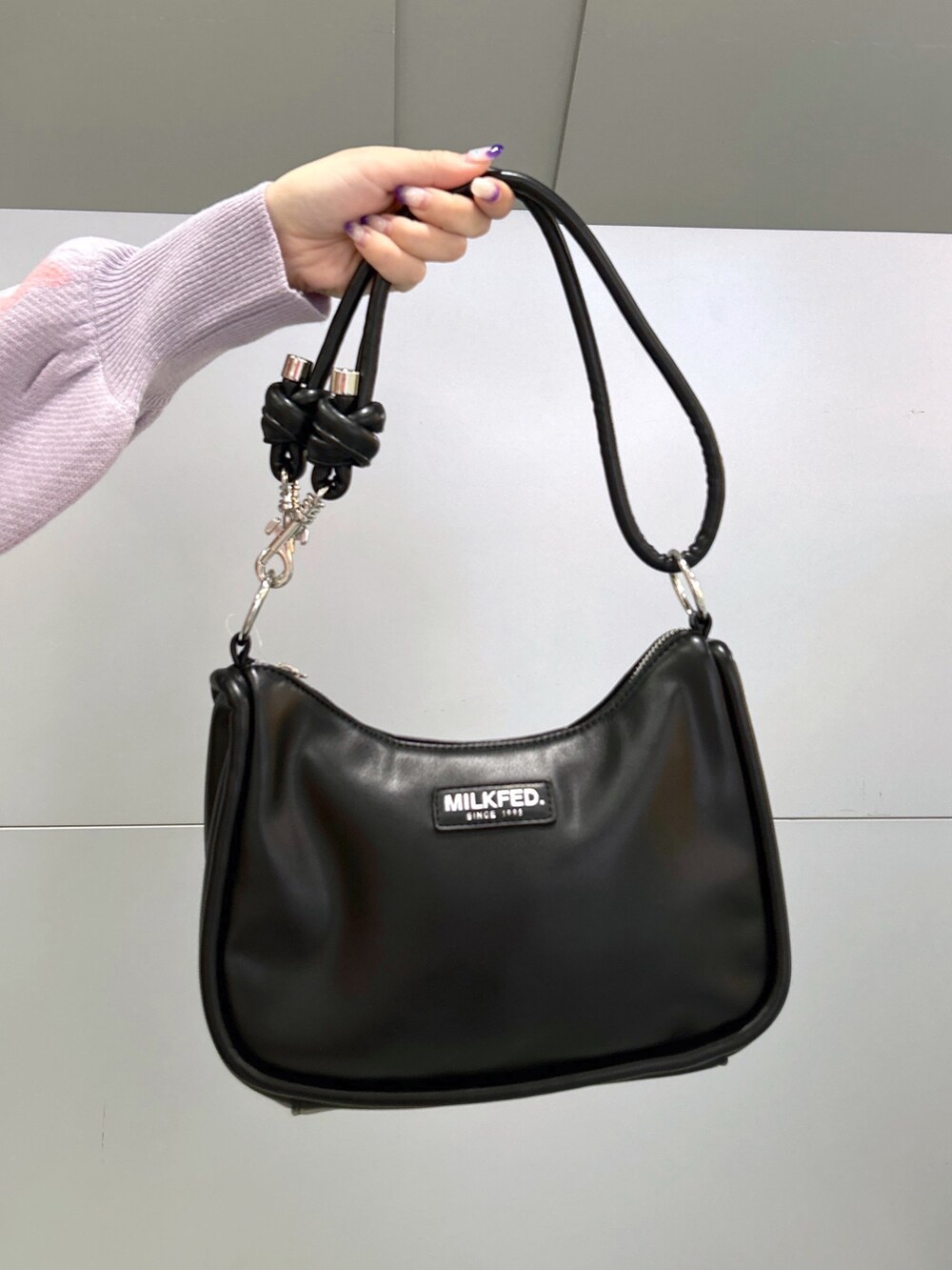 パープル系のニット/セーター、グレー系のジャンパースカート、ブラック系のショルダーバッグを着用したレディースの秋コーディネートの5枚目の写真