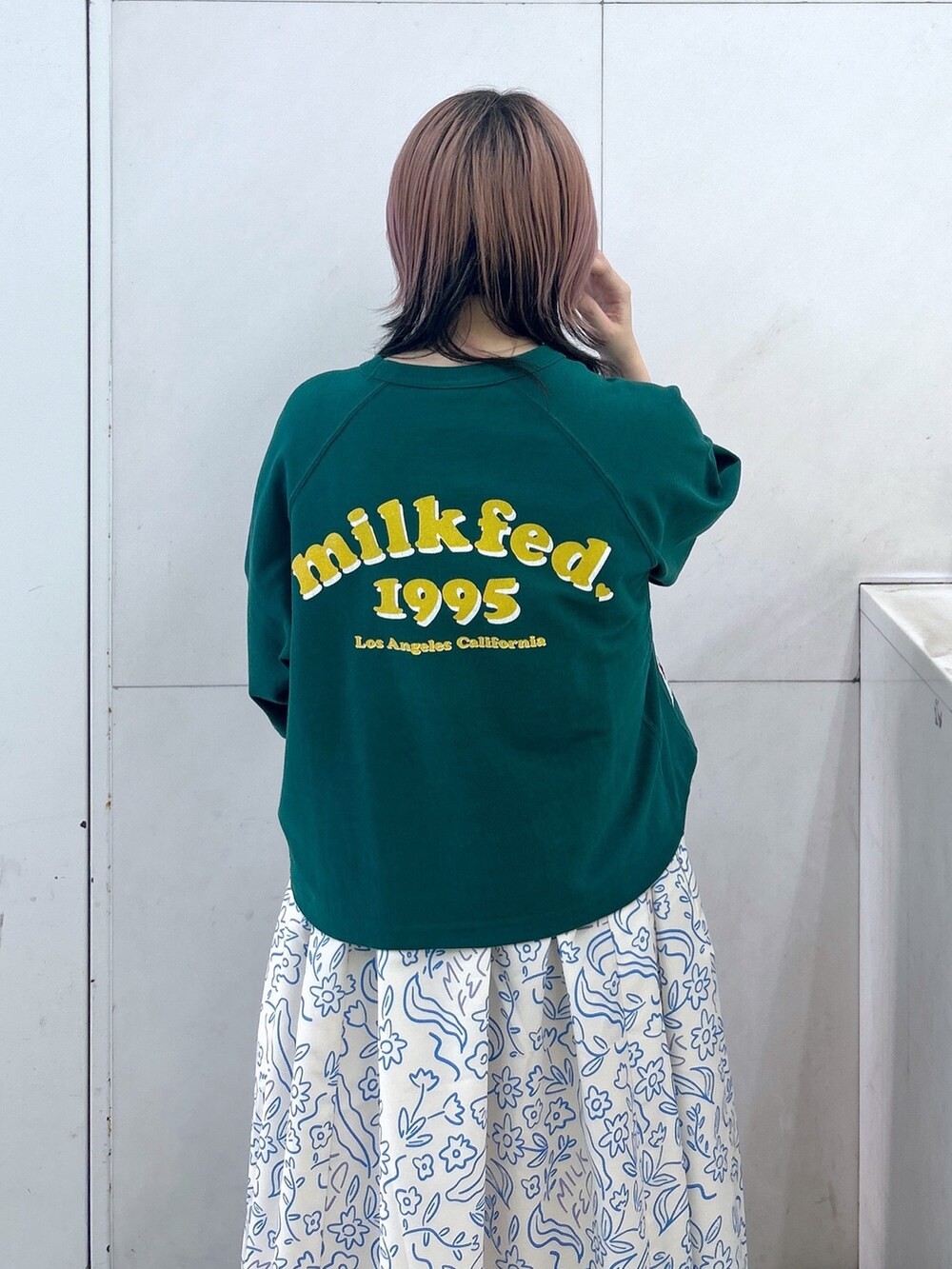 ホワイト系のワンピース、ブラック系のブーツ、グリーン系のショルダーバッグを着用したレディースの夏コーディネートの6枚目の写真