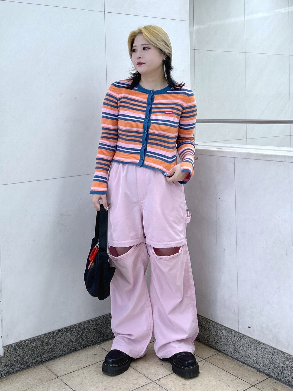 オレンジ系のカーディガン/ボレロ、ピンク系のその他パンツ、ブラック系のハンドバッグを着用したレディースの春コーディネートの3枚目の写真