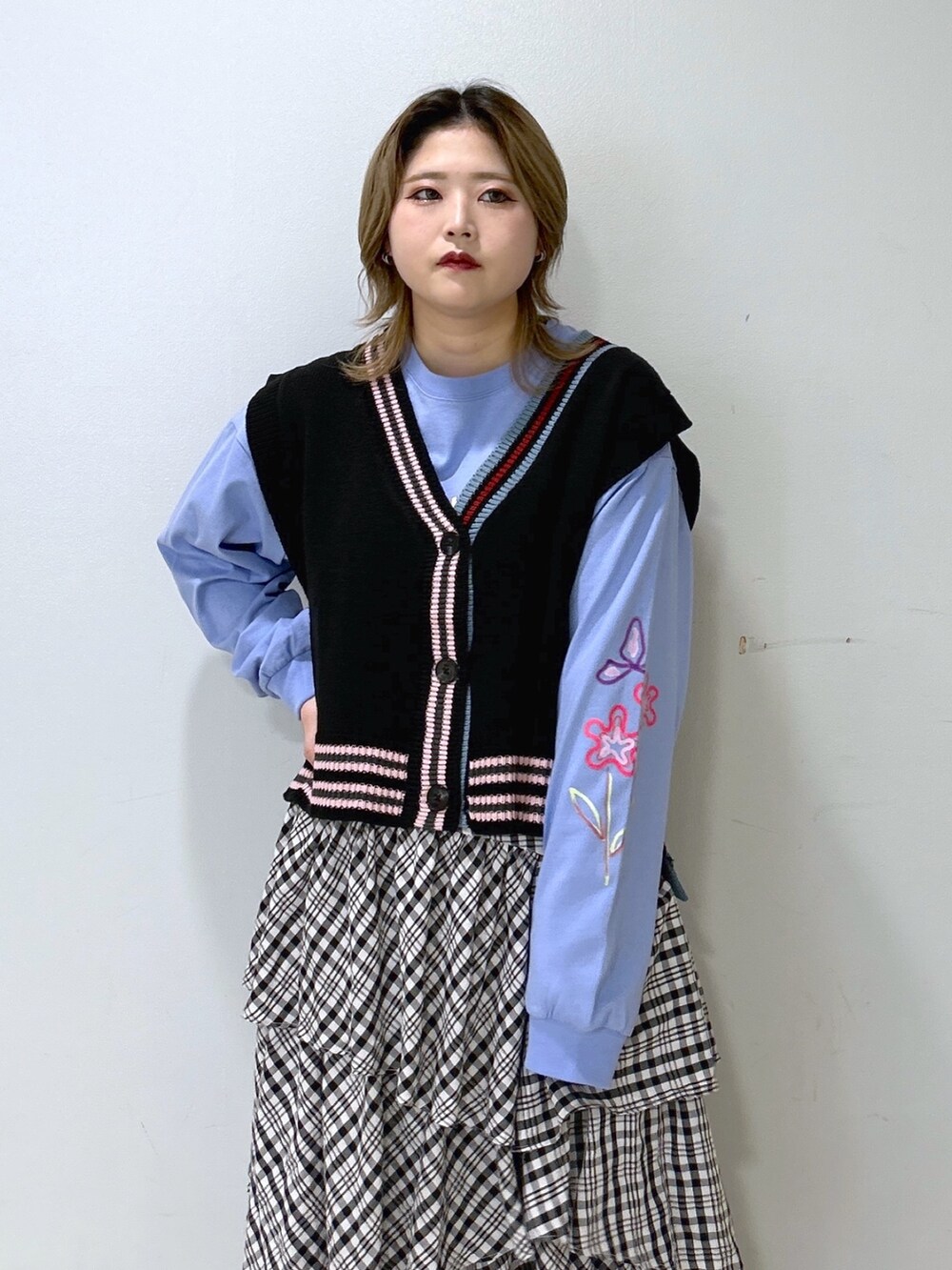 ブラック系のベスト、ブルー系のTシャツ/カットソー、ブラック系のスカートを着用したレディースの冬コーディネートの5枚目の写真