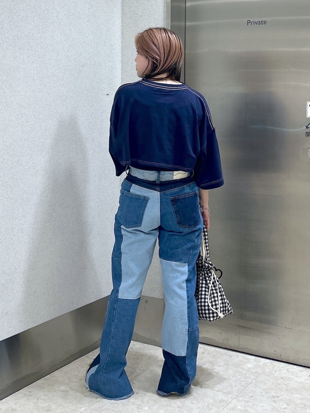 ブルー系のデニムパンツ、ブルー系のTシャツ/カットソー、ベージュ系のサンダルを着用したレディースの夏コーディネートの3枚目の写真