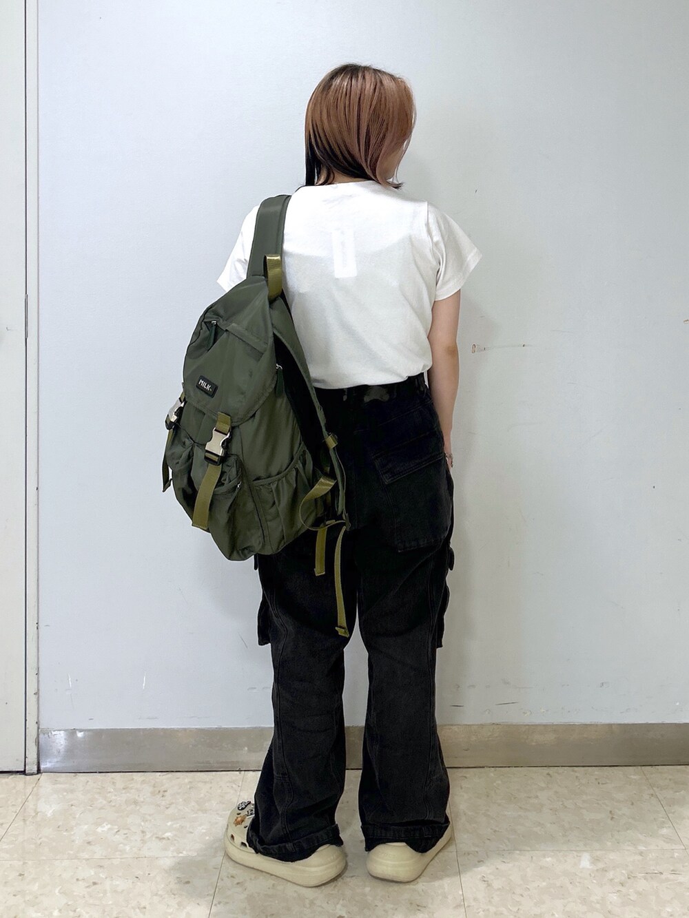 ベージュ系のサンダル、グリーン系のバックパック/リュック、ホワイト系のTシャツ/カットソーを着用したレディースの夏コーディネートの5枚目の写真