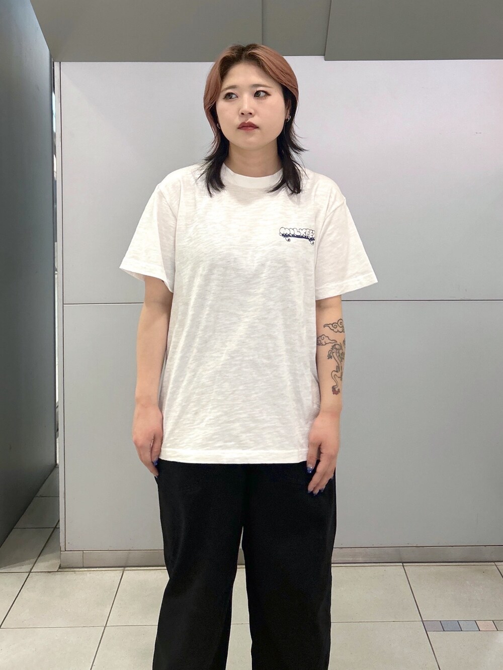 ブラック系のブーツ、ホワイト系のTシャツ/カットソー、ブラック系のデニムパンツを着用したレディースの夏コーディネートの4枚目の写真