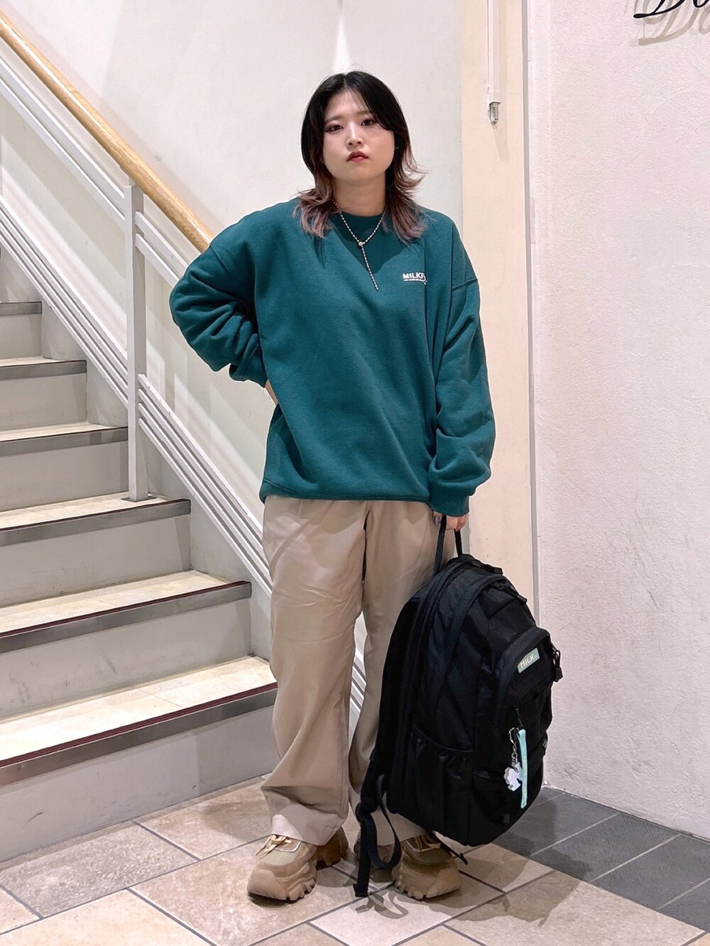 グリーン系のスウェット、ベージュ系のその他パンツ、ベージュ系のスニーカーを着用したレディースの夏コーディネートの3枚目の写真