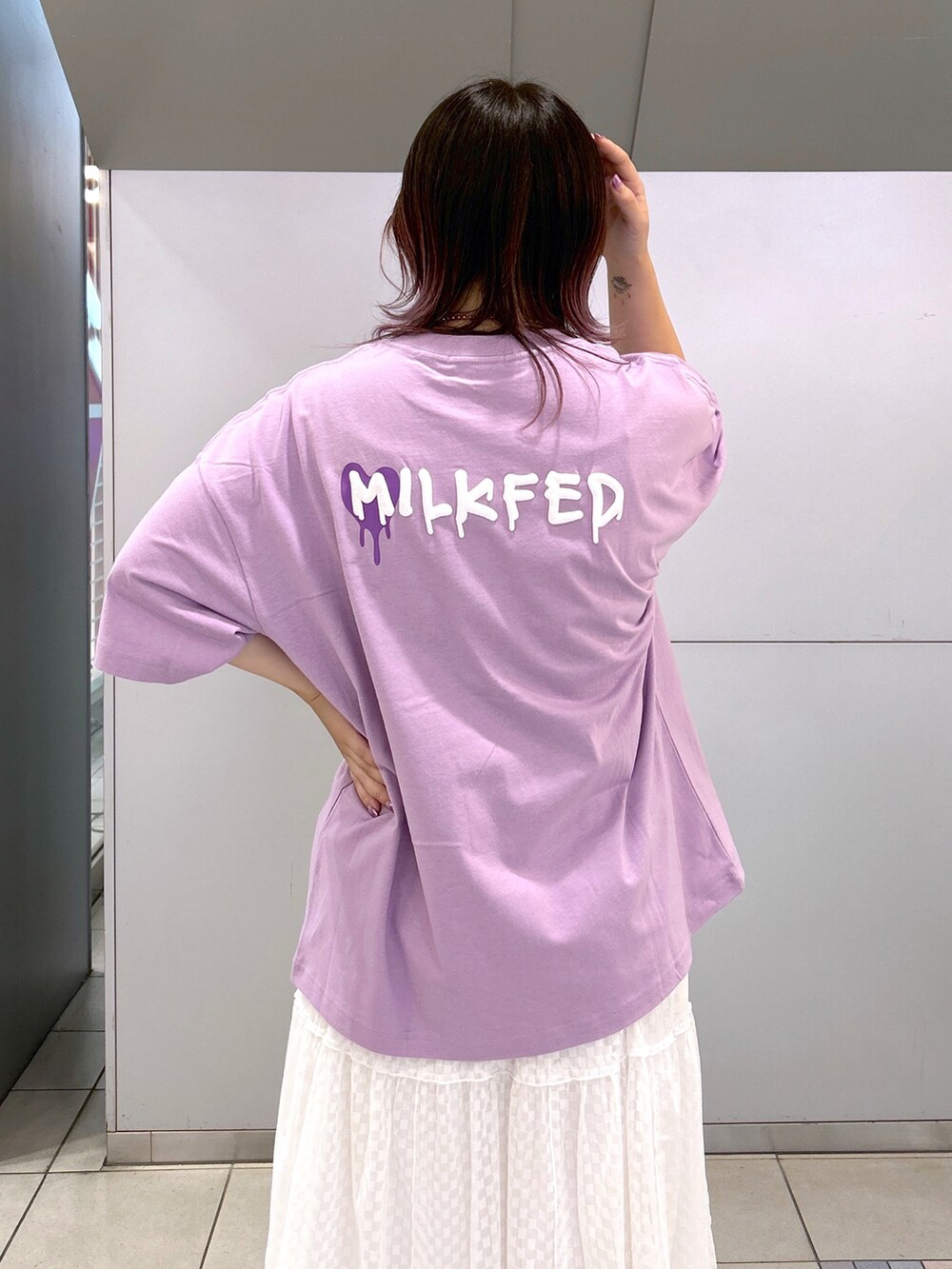 パープル系のTシャツ/カットソー、パープル系のショルダーバッグ、ホワイト系のスカートを着用したレディースの秋コーディネートの3枚目の写真