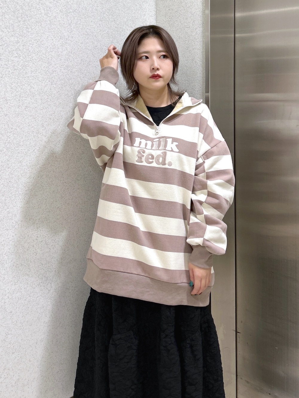 グレー系のスウェット、ブラック系のワンピース、ブラック系のブーツを着用したレディースの冬コーディネートの3枚目の写真