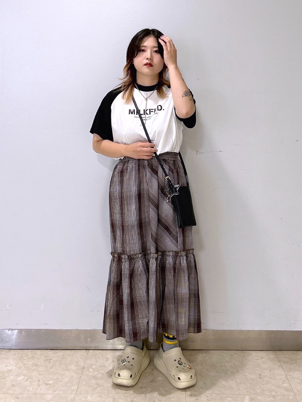 ホワイト系のTシャツ/カットソー、ブラウン系のスカート、ベージュ系のサンダルを着用したレディースの夏コーディネートの3枚目の写真