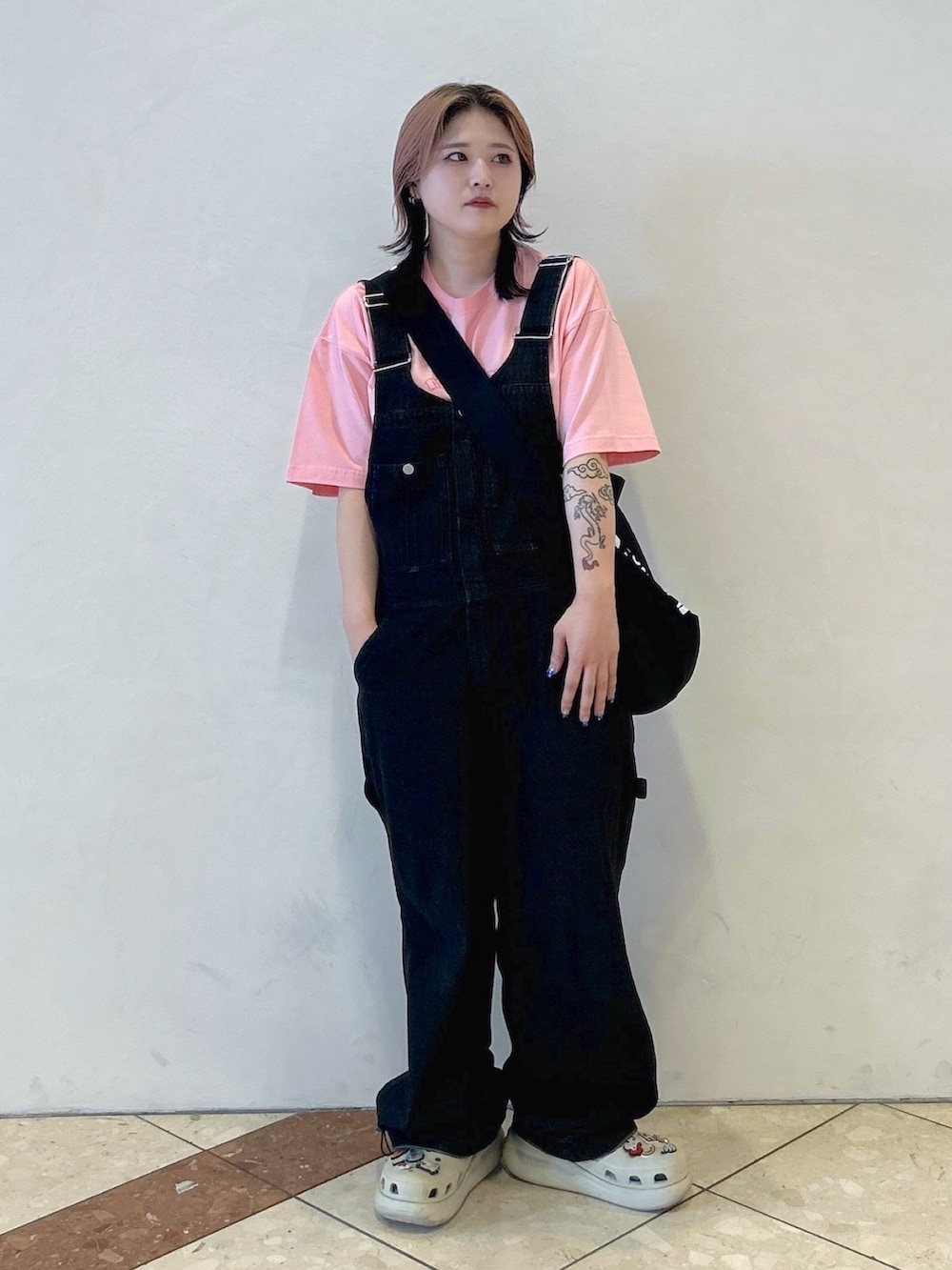 ピンク系のTシャツ/カットソー、ブラック系のショルダーバッグ、ブラック系のサロペット/オーバーオールを着用したレディースの夏コーディネートの3枚目の写真
