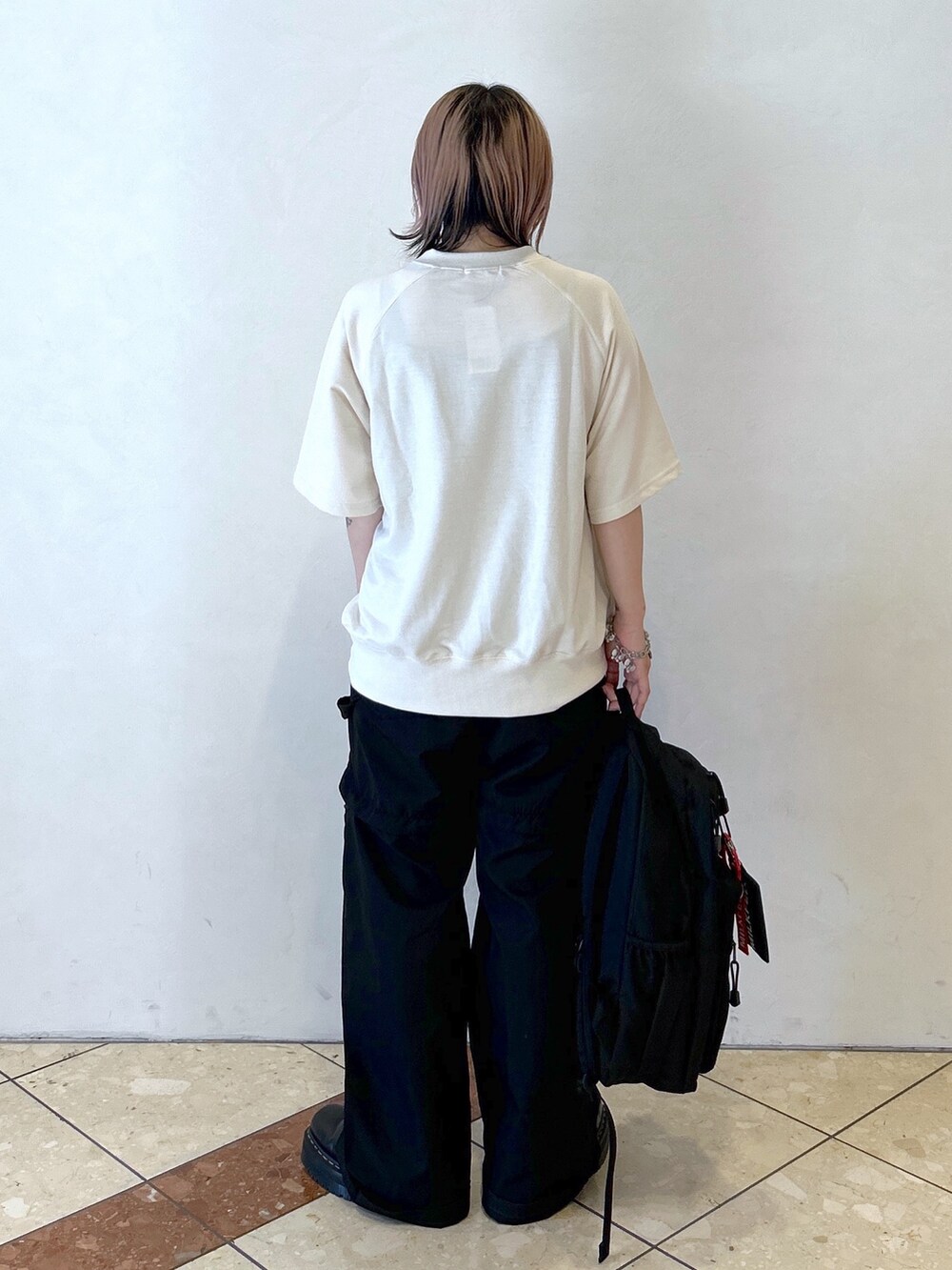 ブラック系のその他パンツ、ブラック系のブーツ、ホワイト系のTシャツ/カットソーを着用したレディースの夏コーディネートの4枚目の写真