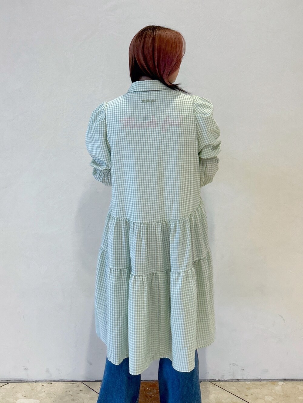 グリーン系のワンピース、ブルー系のデニムパンツ、ブラック系のトートバッグを着用したレディースの夏コーディネートの6枚目の写真