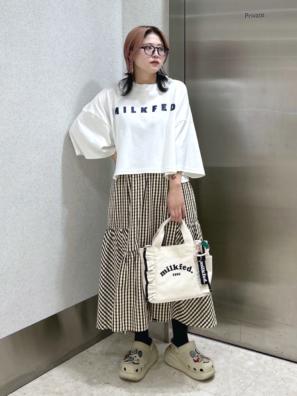 ホワイト系のショルダーバッグ、ベージュ系のサンダル、ホワイト系のTシャツ/カットソーを着用したレディースの夏コーディネートの2枚目の写真