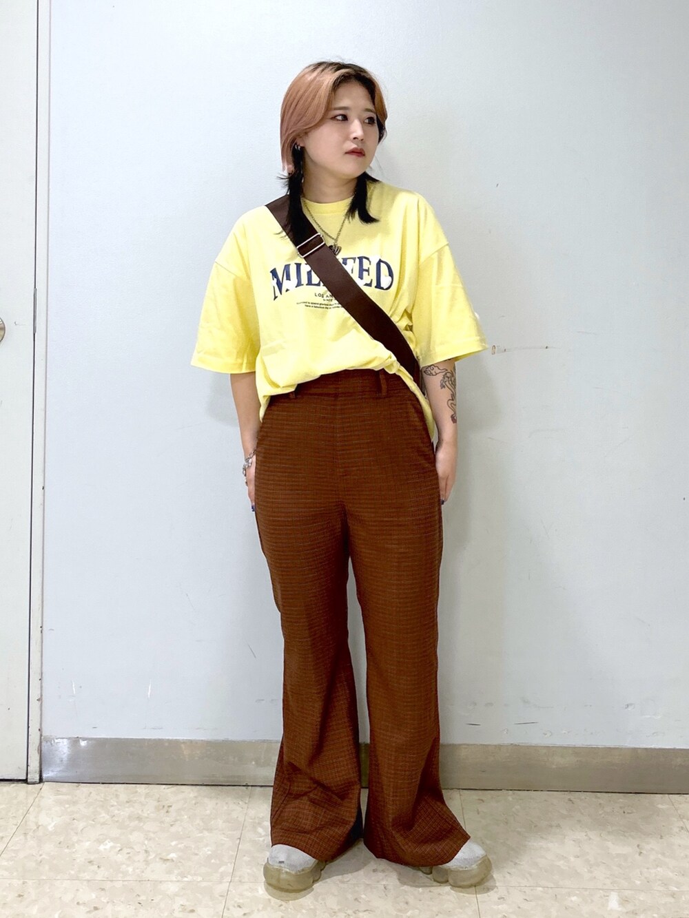 オレンジ系のその他パンツ、ブラウン系のショルダーバッグ、イエロー系のTシャツ/カットソーを着用したレディースの夏コーディネートの3枚目の写真
