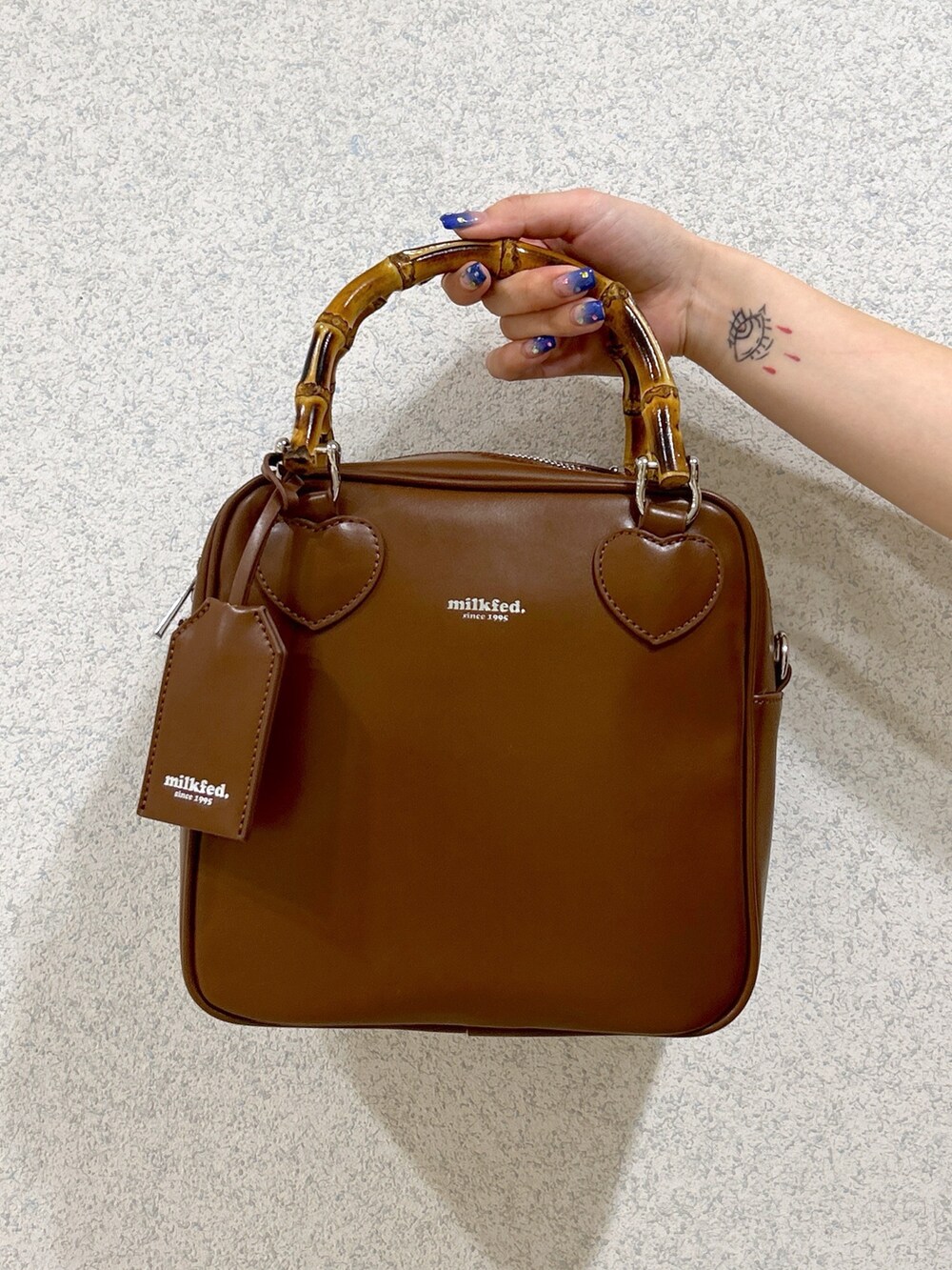 ブラウン系のショルダーバッグ、ベージュ系のサンダル、ブラウン系のスカートを着用したレディースの夏コーディネートの6枚目の写真