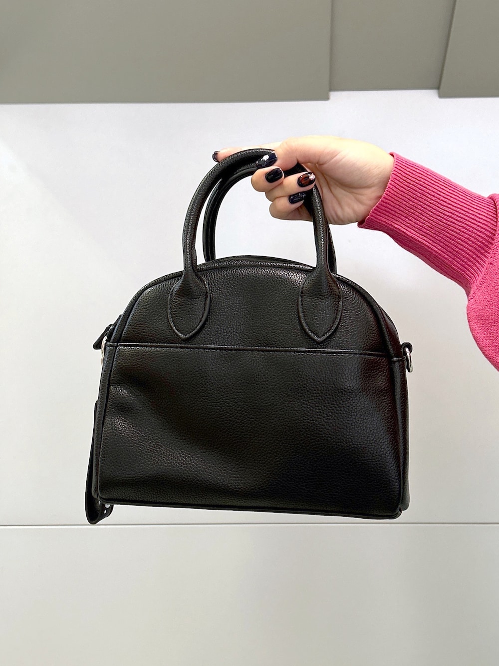 ピンク系のニット/セーター、ブラック系のサロペット/オーバーオール、ブラック系のボストンバッグを着用したレディースの秋コーディネートの5枚目の写真