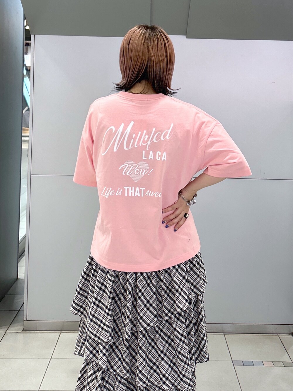 ピンク系のTシャツ/カットソー、ブラック系のスカート、ホワイト系のトートバッグを着用したレディースの夏コーディネートの5枚目の写真