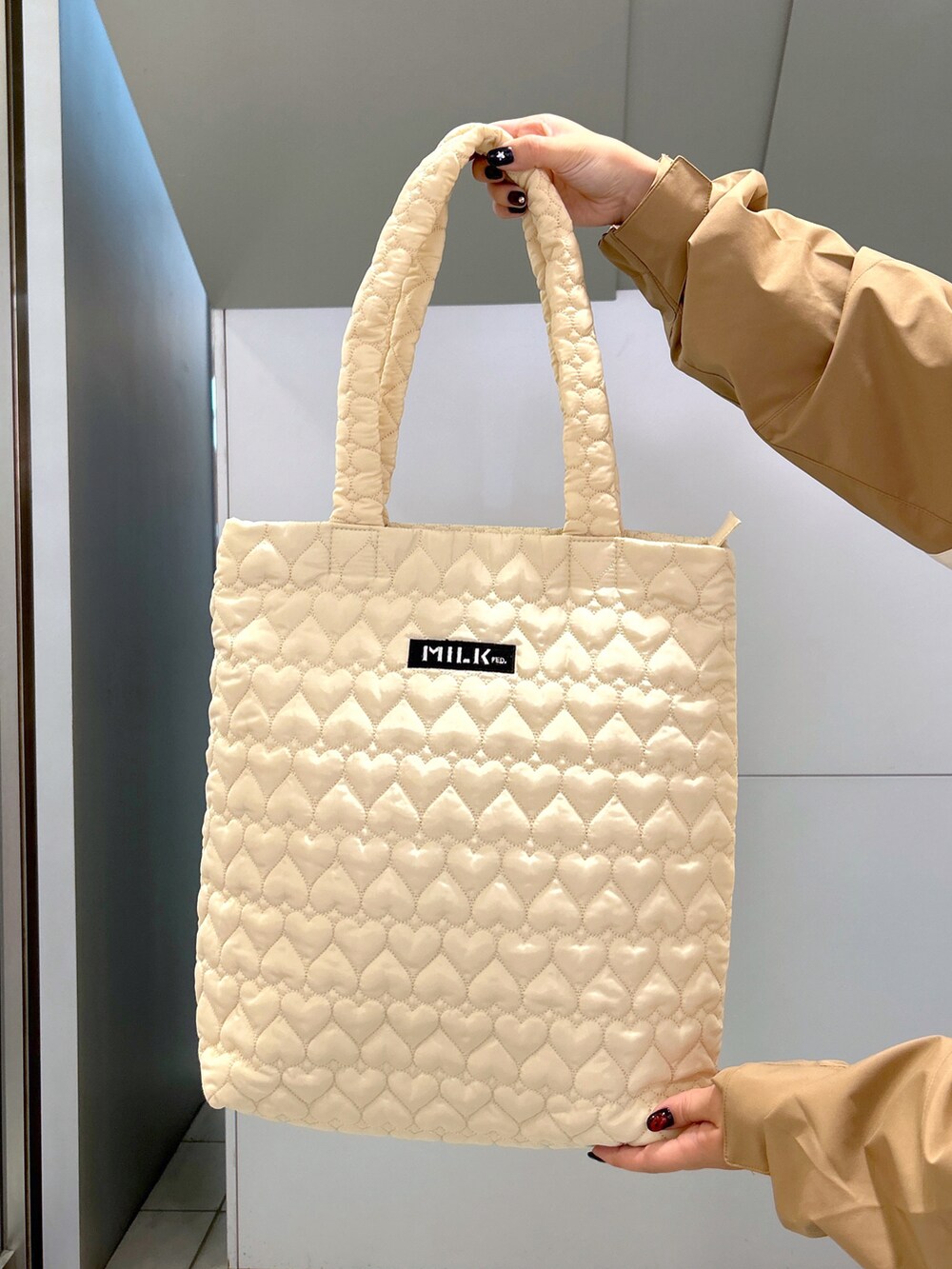 ベージュ系のマウンテンパーカー、ピンク系のニット/セーター、ブラック系のサロペット/オーバーオールを着用したレディースの秋コーディネートの5枚目の写真