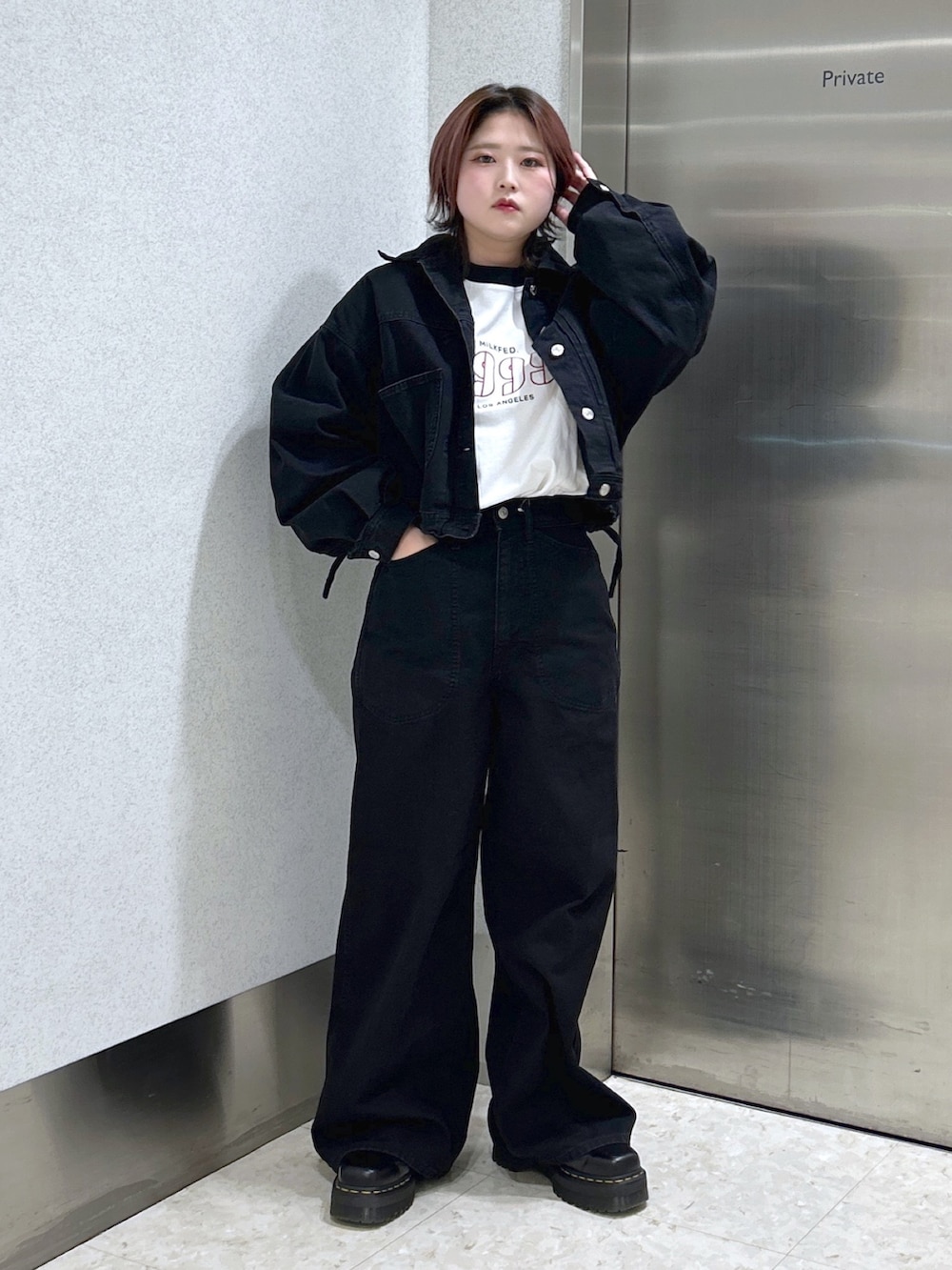 ブラック系のデニムジャケット、ブラック系のデニムパンツ、ブラック系のブーツを着用したレディースの冬コーディネートの2枚目の写真