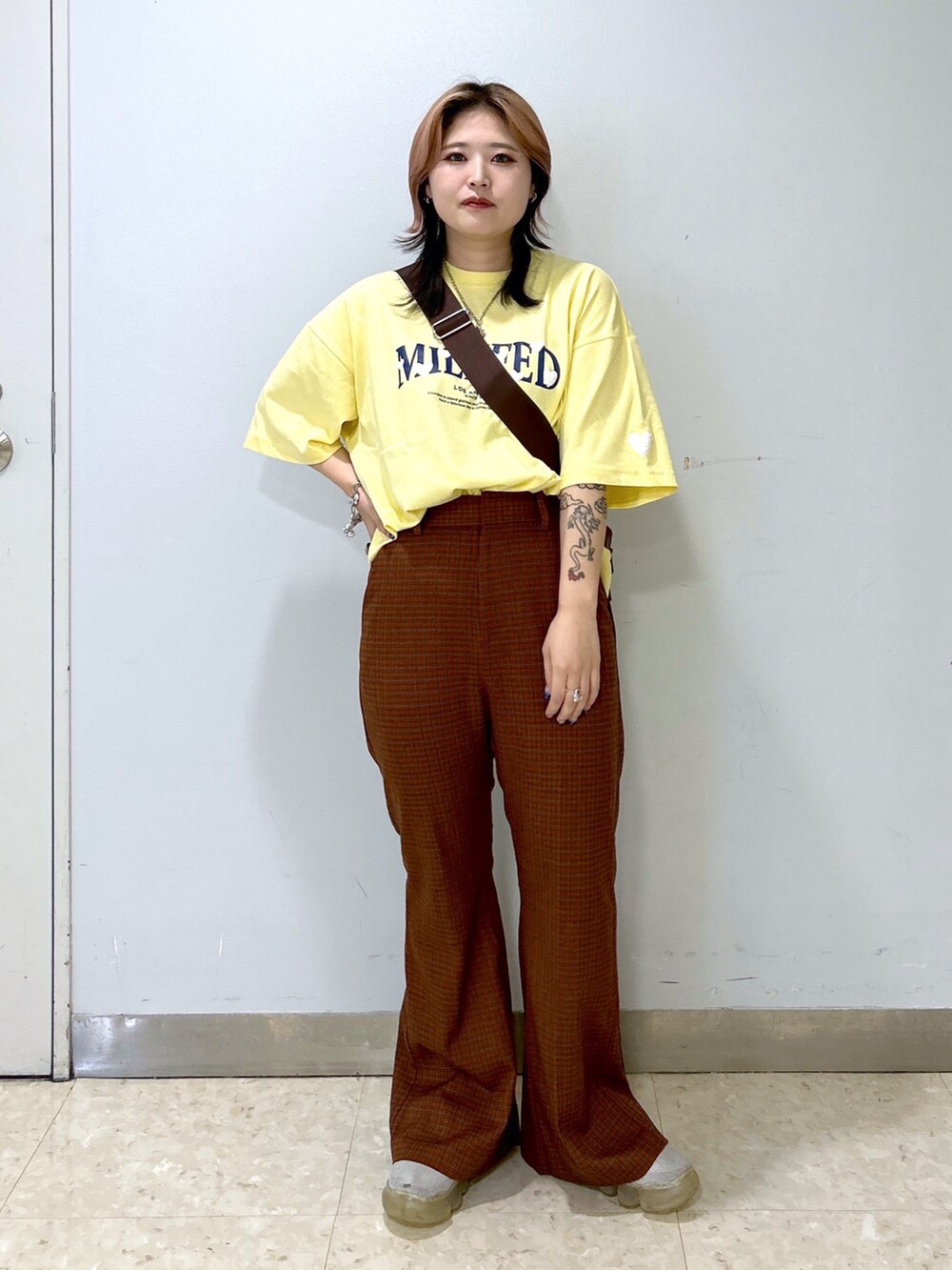 オレンジ系のその他パンツ、ブラウン系のショルダーバッグ、イエロー系のTシャツ/カットソーを着用したレディースの夏コーディネートの2枚目の写真