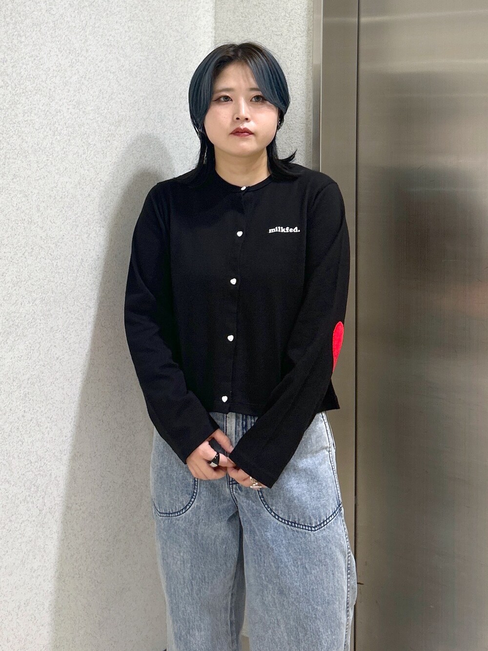 ブルー系のハンドバッグ、ブルー系のデニムパンツ、ベージュ系のサンダルを着用したレディースの夏コーディネートの6枚目の写真