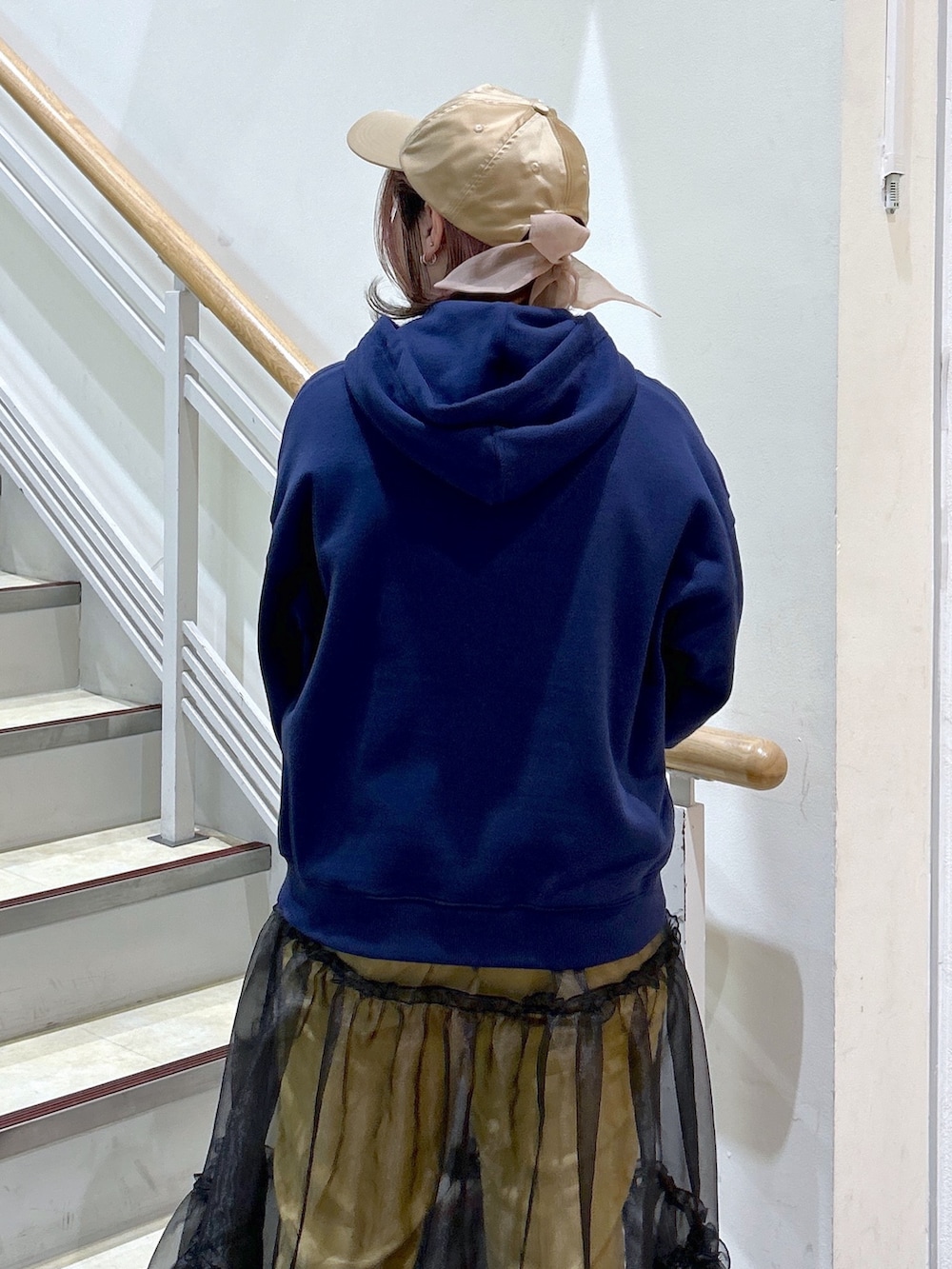 ブルー系のパーカー、イエロー系のその他パンツ、ブラック系のハンドバッグを着用したレディースの冬コーディネートの5枚目の写真