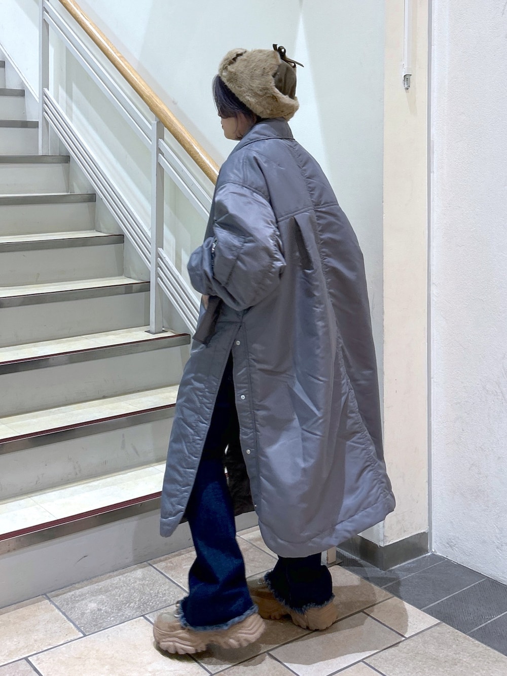 グレー系のMA-1、ブルー系のデニムパンツ、ベージュ系のスニーカーを着用したレディースの秋コーディネートの2枚目の写真