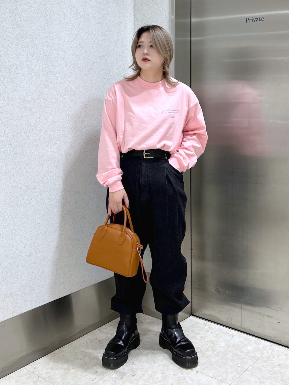 ピンク系のボディバッグ/ウエストポーチ、ピンク系のTシャツ/カットソー、ベージュ系のブルゾンを着用したレディースの冬コーディネートの5枚目の写真