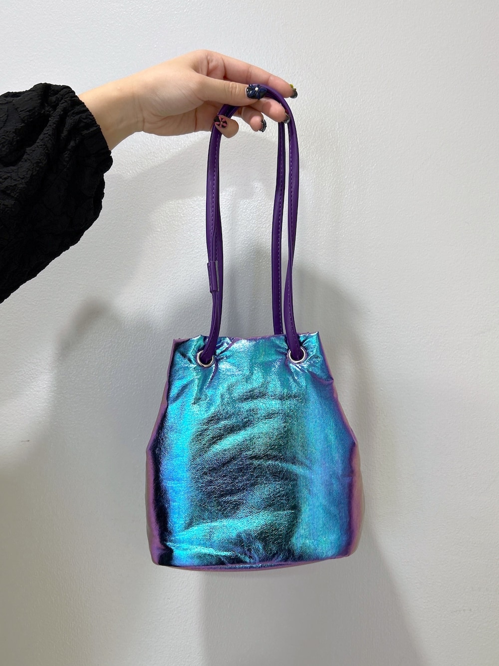 ブラック系のワンピース、パープル系のショルダーバッグ、ベージュ系のスニーカーを着用したレディースの冬コーディネートの5枚目の写真