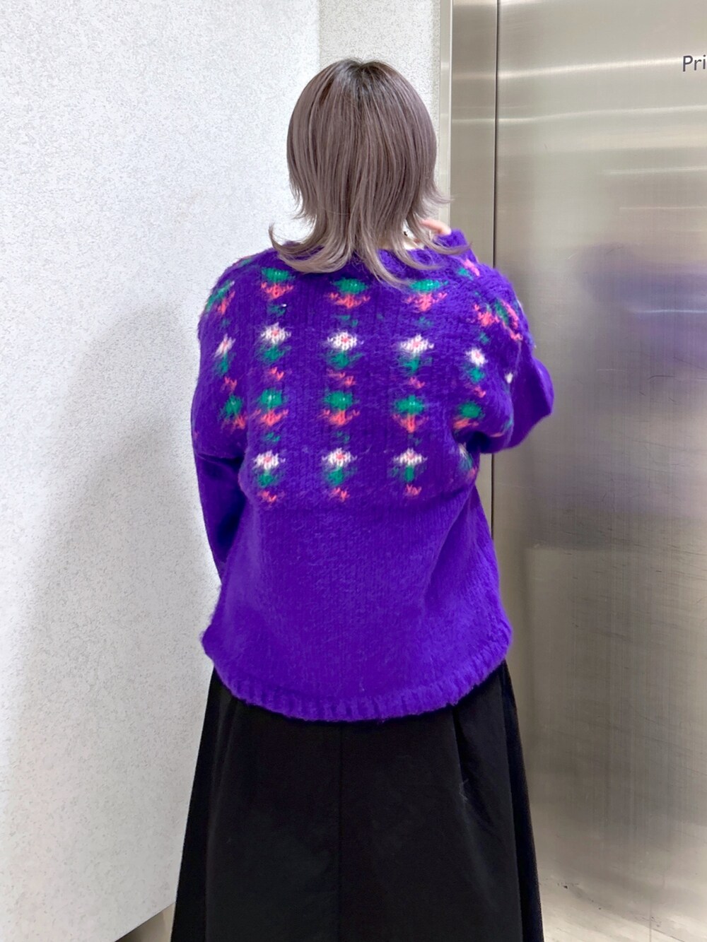 パープル系のカーディガン/ボレロ、ベージュ系のその他トップス、ブラック系のジャンパースカートを着用したレディースの冬コーディネートの4枚目の写真