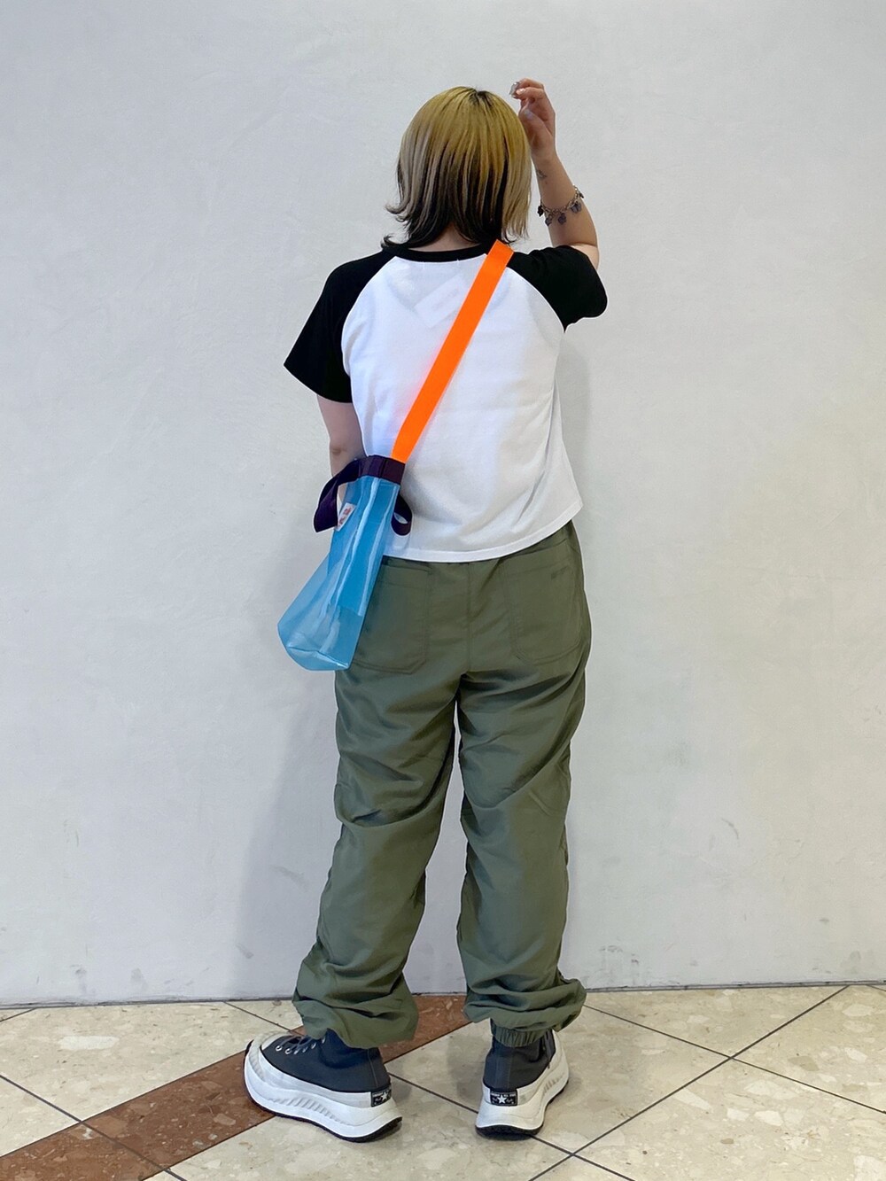 ブラック系のTシャツ/カットソー、グリーン系のその他パンツ、ブルー系のショルダーバッグを着用したレディースの春コーディネートの3枚目の写真