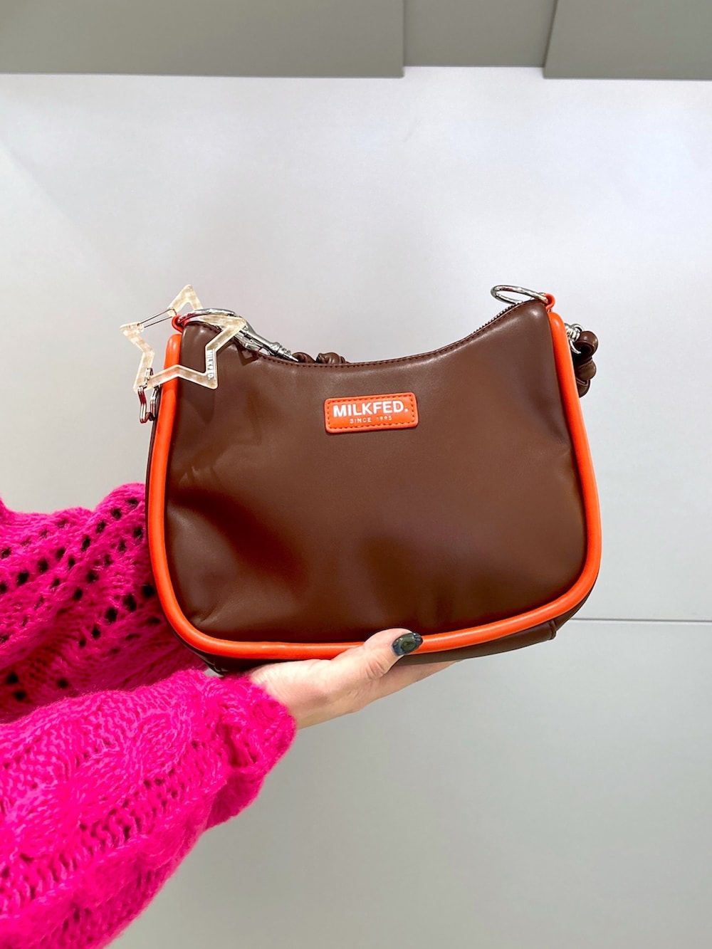 ピンク系のニット/セーター、ブラック系のワンピース、ブラウン系のショルダーバッグを着用したレディースの冬コーディネートの5枚目の写真