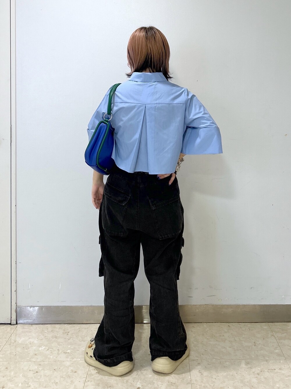 ブルー系のショルダーバッグ、ベージュ系のサンダル、ブルー系のシャツ/ブラウスを着用したレディースの夏コーディネートの4枚目の写真