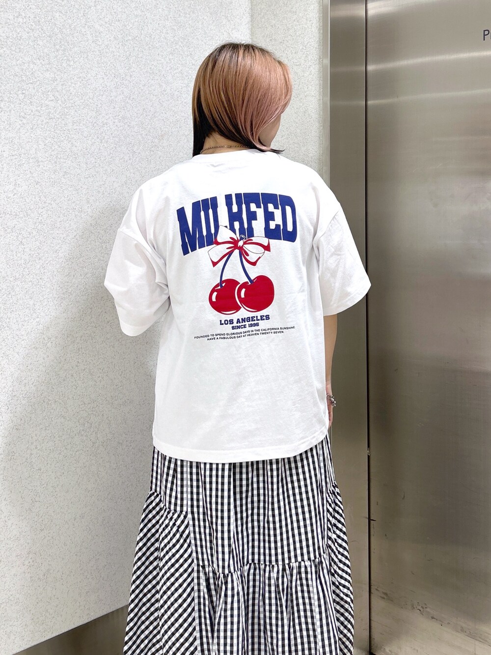 ホワイト系のTシャツ/カットソー、ブラック系のスカート、ブルー系のショルダーバッグを着用したレディースの夏コーディネートの5枚目の写真