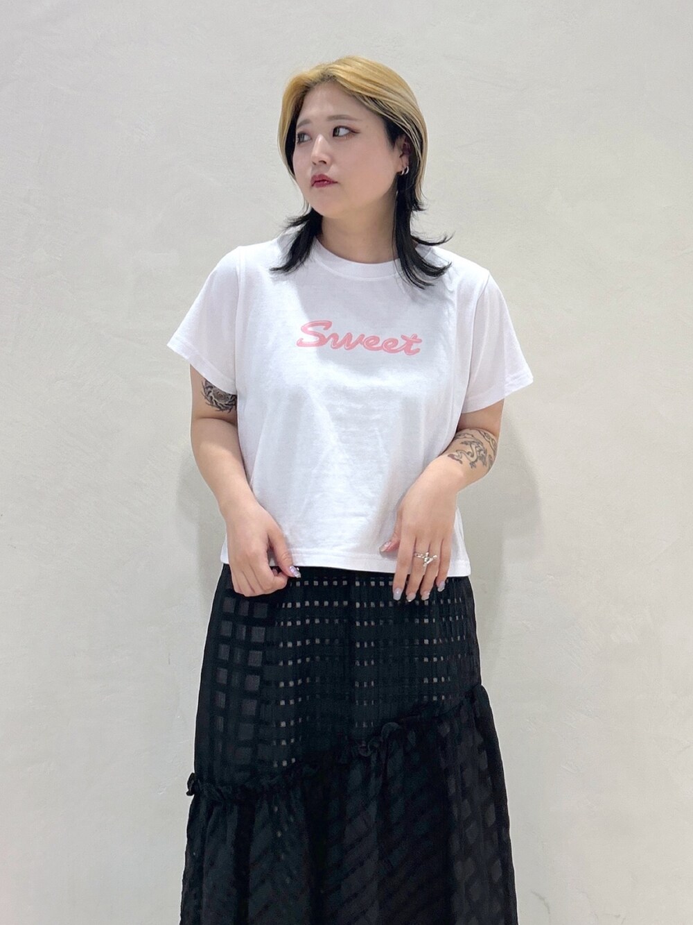 ピンク系のTシャツ/カットソー、ブラック系のスカート、ブラック系のハンドバッグを着用したレディースの春コーディネートの4枚目の写真