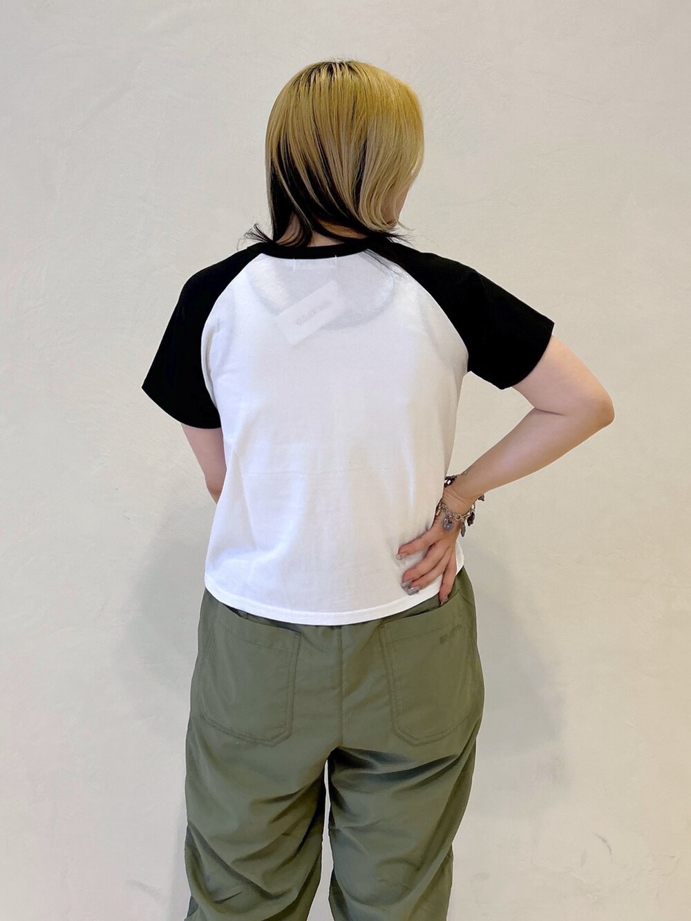 ブラック系のTシャツ/カットソー、グリーン系のその他パンツ、ブルー系のショルダーバッグを着用したレディースの春コーディネートの5枚目の写真