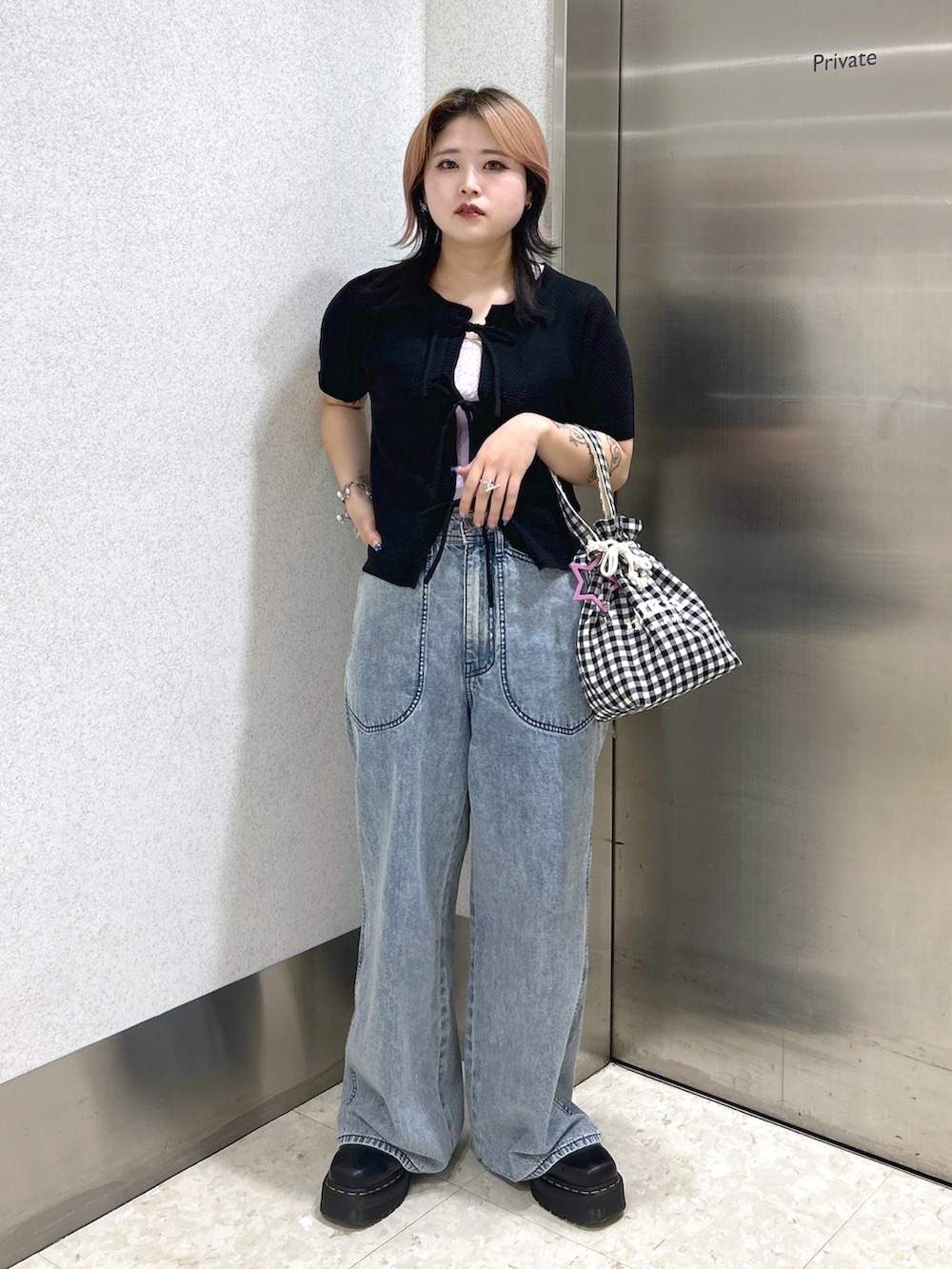 ブルー系のデニムパンツ、パープル系のタンクトップ、ブラック系のカーディガン/ボレロを着用したレディースの夏コーディネートの2枚目の写真